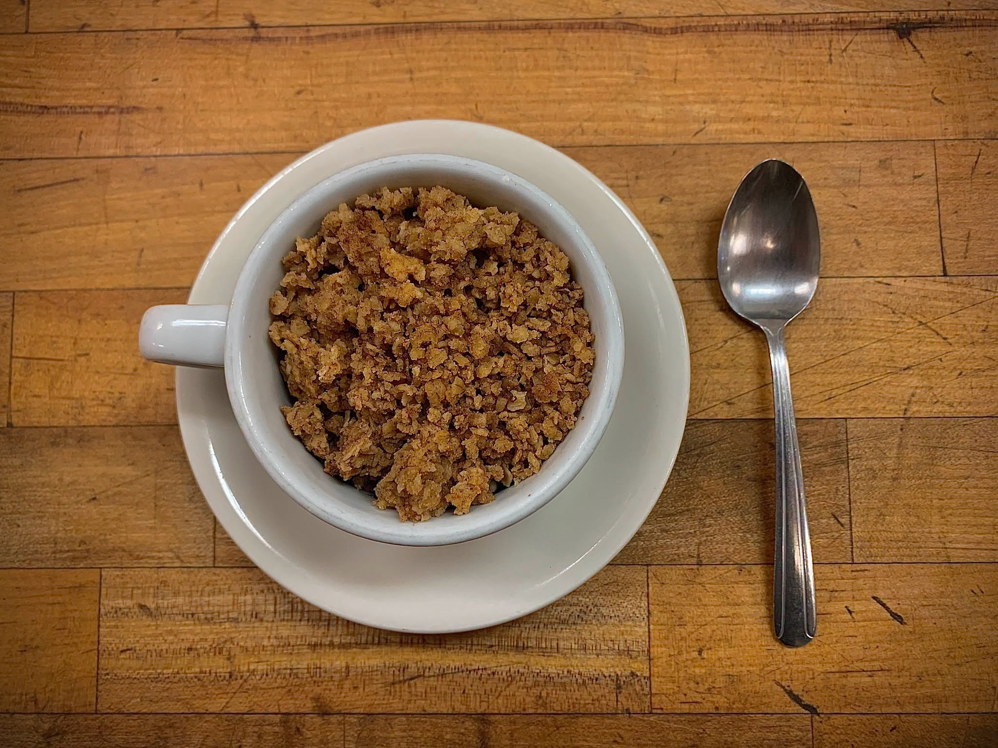 A cup of housemade granola with a spoon