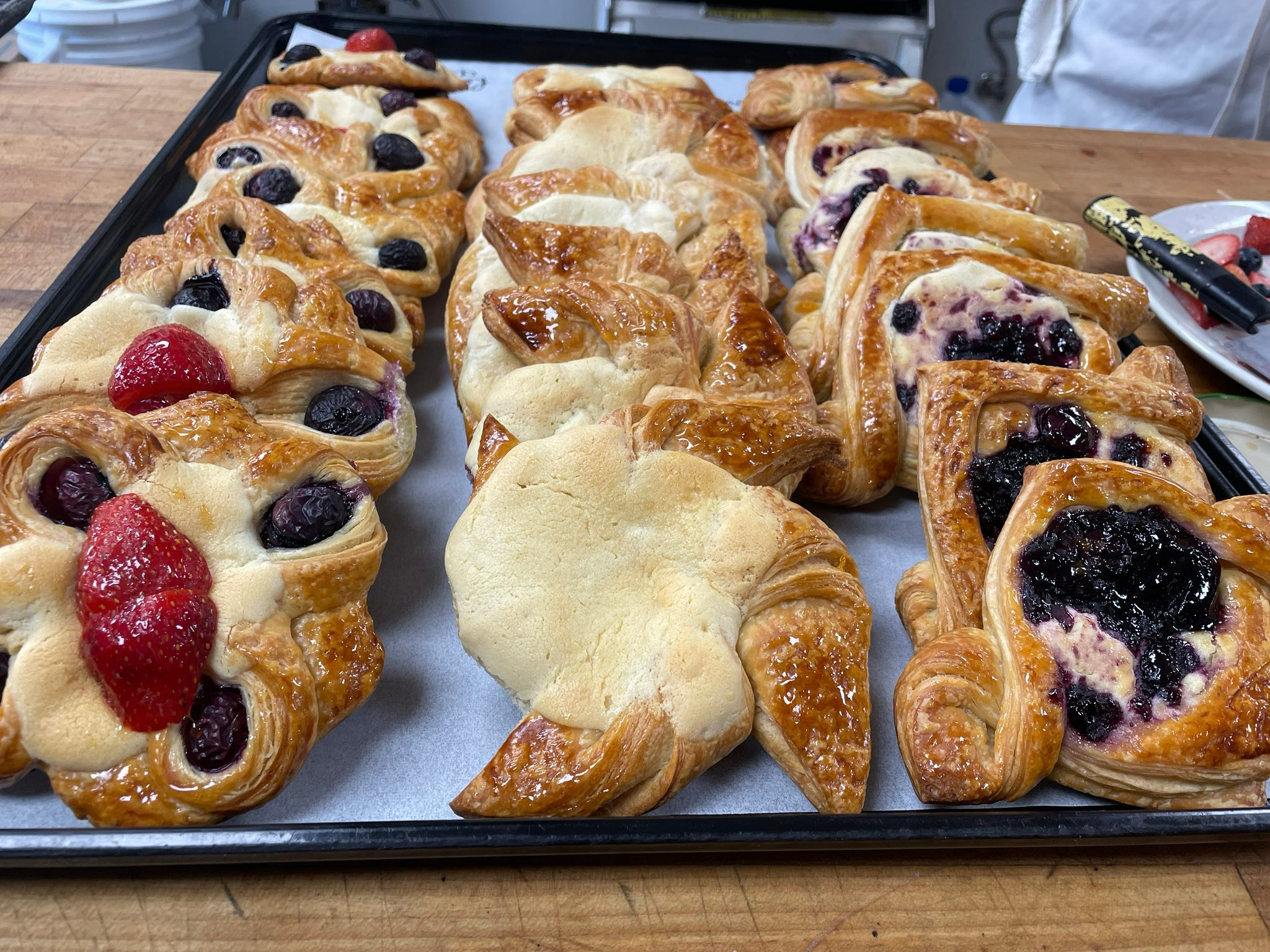 A tray of fresh fruit-topped Danish pastries