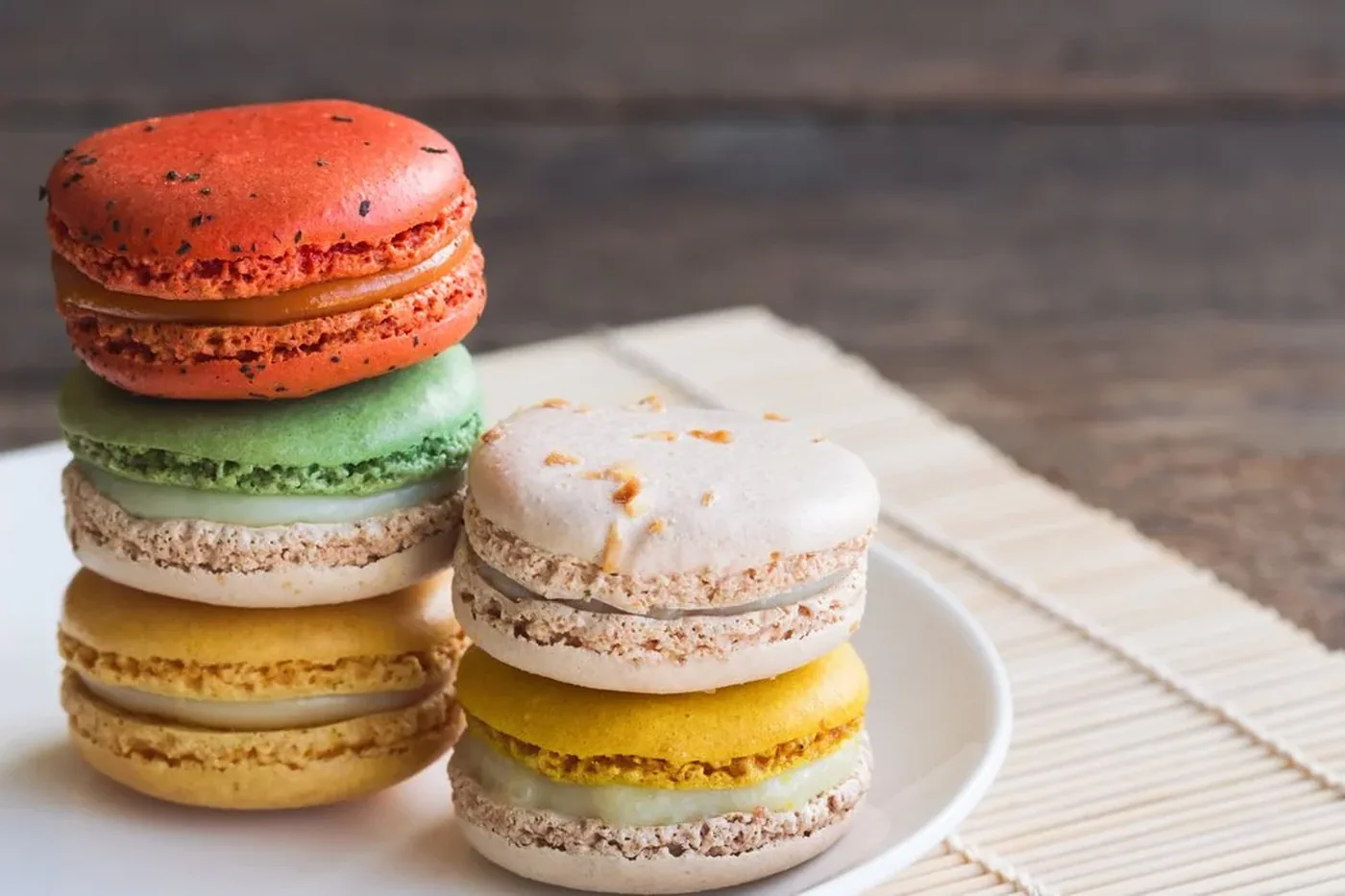A stack of colorful French macarons on a wooden table